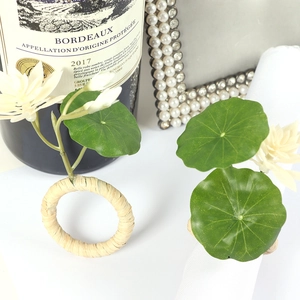 Handwoven straw napkin ring with artificial green leaves and white lotus flower decoration