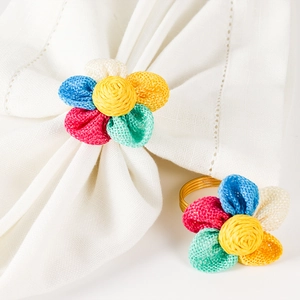 Dettaglio di portatovaglioli a forma di fiori colorati in tela di juta rustica