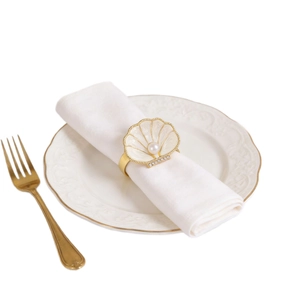 Rond de serviette coquillage doré avec perle et strass sur serviette blanche