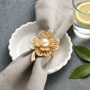Detailed view of luxury gold clover flower napkin ring with a central white pearl inlay