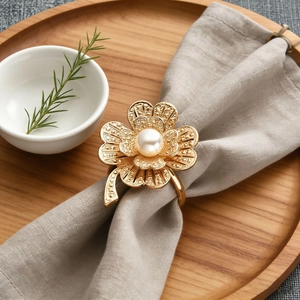 Luxurious gold flower napkin ring with central pearl and textured petals for table decor