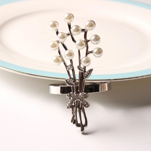 Dettaglio portatovagliolo con bouquet di perle, fiocco d'argento e strass lucidi