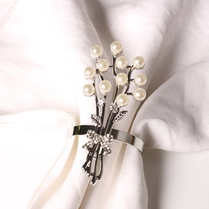 Dettaglio portatovagliolo argento con ramo di rose di perle e decorazione fiocco di strass