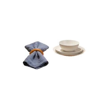 Natural wooden napkin ring with textured blue cotton linen napkin and white ceramic tableware