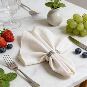 Elegant silver hammered metal napkin ring on white marble table with dining decor