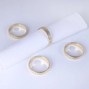 Set of four gold hammered texture napkin rings for elegant table decor and settings