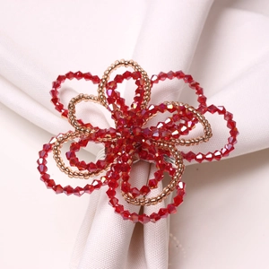 Detail of a handmade red beaded flower napkin ring with elegant gold seed bead accents