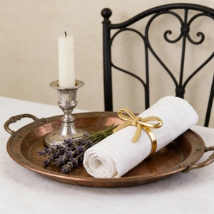 Detailed close-up of golden bow napkin ring on white fabric in a vintage setting