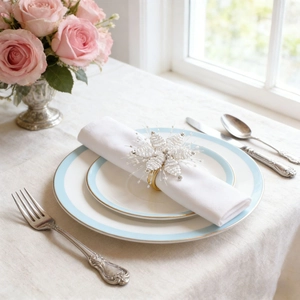 Detail of white beaded snowflake napkin ring with gold band on an elegant dining table