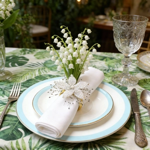 Close-up of handmade white beaded flower napkin ring with a sparkling crystal center