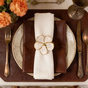 Elegant cream flower napkin ring with gold edges on a vintage luxury dining table set