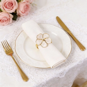 French cream floral napkin ring with gold base on a luxury dining table setting
