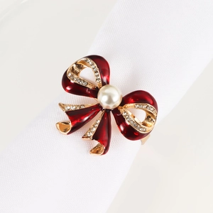 Detailed view of red enamel bow napkin ring with white pearls and sparkling crystals