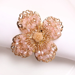Detail eines rosa Kristallperlen-Serviettenrings mit Rose auf weißem Stoff