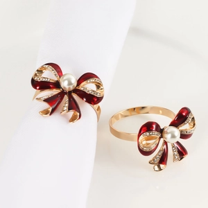 Elegant red enamel bow napkin rings with gold finish, pearls, and crystals for table decor