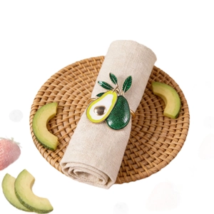 Dettaglio dell'anello portatovagliolo avocado in smalto su panno di cotone