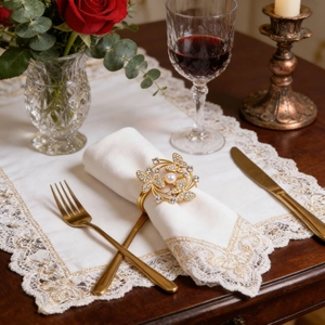 Detailed view of a gold flower napkin ring with crystals and a central white pearl