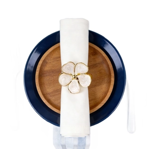 French cream floral napkin ring with gold edges and pearl finish on a white napkin