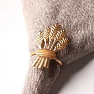 Eleganter goldener Serviettenring in Ährenform auf Leinen für die Hochzeitstafel