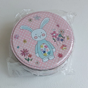 Détail de la boîte de Pâques rose à pois avec motif de lapin et décorations florales