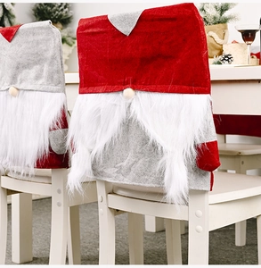 Close-up of festive Christmas gnome chair covers made of red felt with plush white beards
