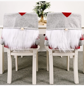 Detailed view of two Christmas gnome chair covers with red hats and white long beards