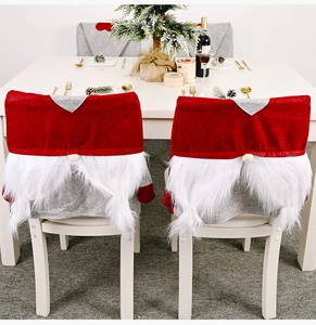 Detail of Christmas gnome chair cover with plush white beard in a festive dining room setting
