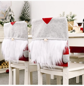 Detail of Christmas gnome chair cover with red hat and white faux fur beard for dining decor
