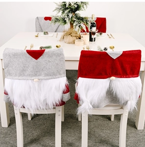Detail of Christmas gnome chair covers in red and grey with plush white beards and soft hats