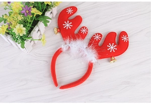 Close-up of red Christmas reindeer antler headband with white feathers and gold bells
