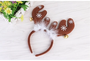 Detail of Christmas reindeer antler headband with white feathers and golden bells