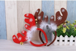 Close-up of reindeer antlers headband with white snowflakes and gold metal bells