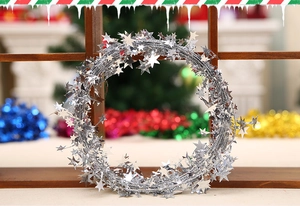 Silver Christmas garland featuring metallic star sequins on a festive rustic wood background