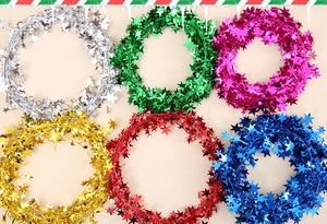 Detail showing colorful Christmas star garlands in silver, green, pink, gold, red, and blue