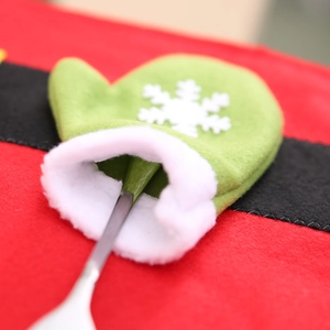 Weihnachtliche Bestecktasche als grüner Handschuh mit Schneeflocke und Silberlöffel