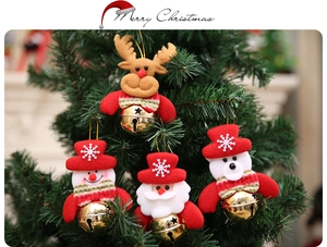 Dettaglio di ciondoli natalizi in peluche con campanelli dorati sull'albero di Natale