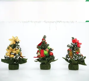 Three 20cm mini Christmas trees with gold flowers, red bows and snowy finish detail