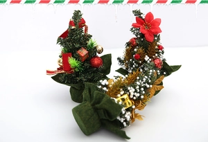Detailed view of 20cm mini Christmas trees with red bows, gold bells and faux snow