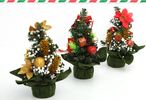 Detailed view of three mini Christmas trees with gold ornaments and snow dusting