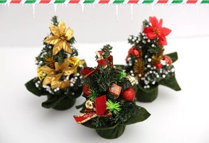 Three 20cm mini Christmas trees with gold flowers, red bows and snowy decorations
