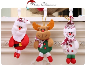 Three plush Christmas ornaments featuring Santa, reindeer, and snowman on fireplace