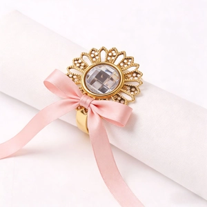 Detail of sunflower napkin ring with gold finish, center crystal and pink satin bow