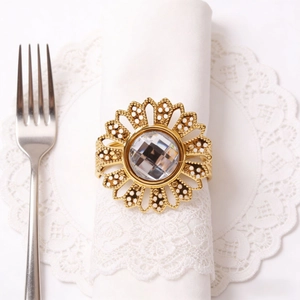 Elegant gold sunflower napkin ring with crystal center on a white lace napkin