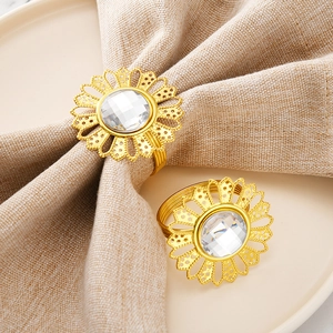 Golden sunflower napkin ring with crystal center on a white plate and linen napkin