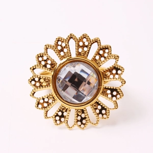 Macro shot of golden sunflower napkin ring with crystal center and hollow petal design