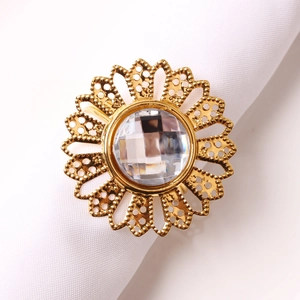 Macro detail of sunflower napkin ring with large central crystal and gold metal petals