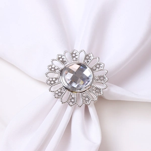 Silver sunflower napkin ring with crystal centerpiece on elegant white silk fabric