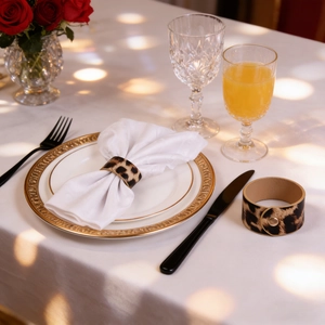 Leopard print leather napkin ring with golden buckle detail on elegant dining table