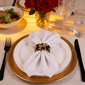 Leopard print leather napkin ring with golden metal clasp on a luxury dining table set