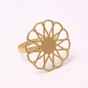 Detail of gold alloy napkin ring featuring an intricate hollow sunflower geometric design